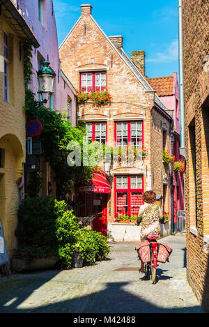 Brügge, Belgien - 1 September, 2017: Straße mit einer Frau Radfahren in der mittelalterlichen Stadt Brügge, Belgien. Stockfoto