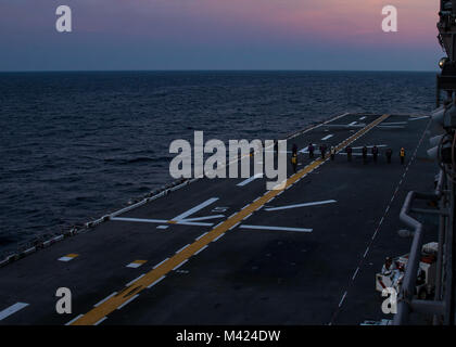 Atlantik (Feb. 9, 2018) Segler sweep das Flight Deck für fremde Gegenstände an Bord der Amphibisches Schiff USS Iwo Jima (LHD7) Vor dem Flugbetrieb. Die Iwo Jima Amphibious Ready Group (ARG) ist zur Unterstützung der Maritime Security Operations und Theater Sicherheit Zusammenarbeit in Europa und im Mittleren Osten eingesetzt werden. Die Iwo Jima ARG begibt sich die 26 Marine Expeditionary Unit und umfasst die Iwo Jima, die amphibious Transport dock Schiff USS New York (LPD-21), das Dock Landung Schiff USS Oak Hill (LSD 51), Flotte Op-Team 8, Hubschrauber Meer Combat Squadron 28, Tactical Air Control Sq Stockfoto