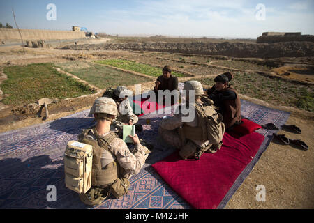 Us-Marines mit Task Force (Südwest) (TFSW) Treffen mit afghanischen Polizisten während einer Patrouille in der Nähe von Bost Flugplatz, Afghanistan, Jan. 24, 2018. Die Begegnung half TFSW's Verpflichtung zur Unterstützung der afghanischen nationalen Verteidigungs- und Sicherheitskräfte (ANDSF) mit mehr Funktionen für zu helfen, eine hohe betriebliche Tempo mit konstanten Betrieb um Provinz Helmand pflegen bekräftigen. (U.S. Marine Corps Foto von Sgt. Sean J. Berry) Stockfoto