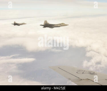 F-22 Raptors aus der Texas Air National Guard fliegen entlang einer KC-135 R vor dem Erwerb durch die 117 Luftbetankung Flügel, Sumpter Smith Air National Guard Base, Birmingham, Ala., 24. Januar 2018 betankt. (U.S. Air National Guard Foto: Staff Sgt. Jim Bentley) Stockfoto