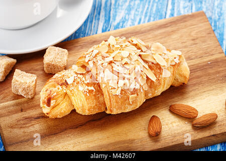 Nahrhafte köstliches Frühstück mit schwarzer Kaffee mit Croissants in den Mandelflocken Stockfoto