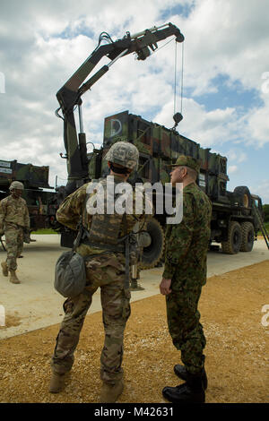 Us-Armee Kapitän Friedrich Sherman, Links, zeigt Japan Masse Verteidigung-kraft Oberst Eiji Shimamori ein Training Website während einer Tour von Air Defense Artillery website Jan. 30 Auf der Marine Corps Air Station Futenma, Okinawa, Japan. Während der ganzen Tour, die Soldaten erklärt sechs verschiedene entscheidende Teile der Ausbildung vor Ort. Diese enthalten: ein Engagement Control Station, eine Radarstation, einem elektronischen Kraftwerk, antennenmast Gruppe, ein Patriot Aussetzstation und missile Segment enhancement Start Station. Sherman ist mit 1-1 Air Defence Battalion. Shimamori ist der kommandierende Offizier des 15 Anti-air Stockfoto