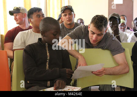 Soldaten der Task Force Darby und 1 Bataillon, 87 Infanterie Regiment, 1st Brigade Combat Team, 10 Mountain Division, Freiwilliger an der American Corner in Garoua, Kamerun. Diese Veranstaltung, die von der US-Abteilung der Staatlichen, Amerikaner und Kameruner eine Gelegenheit, Kultur und Erfahrungen auszutauschen. Spc. Zachary Saxton liest ein beachten Sie, dass eines der Kinder, die für ihn schrieb. TF Darby dienen Mitglieder sind in einer unterstützenden Rolle für den Kamerunischen militärischen Kampf gegen die gewalttätigen extremistischen Organisation Boko Haram zu dienen. Stockfoto