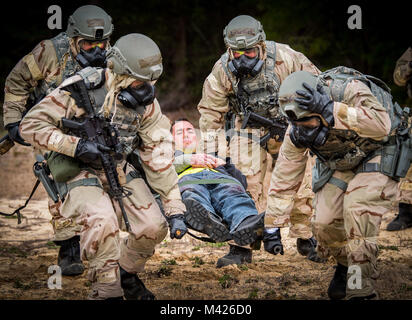 Flieger heben simulierten Verletzten Opfer auf einer Bahre während eines chemischen, biologischen, radiologischen, nuklearen und explosiven Übung in Eglin Air Force Base, Fla., Nov. 1. Die Ausübung beurteilt die Fähigkeit der Flieger zu Kriegszeiten und Kontingenz taskings der Beschäftigung und der Erhaltung der Kraft und der Fähigkeit, zu überleben und zu bedienen. (U.S. Air Force Foto/Samuel King Jr.) Stockfoto
