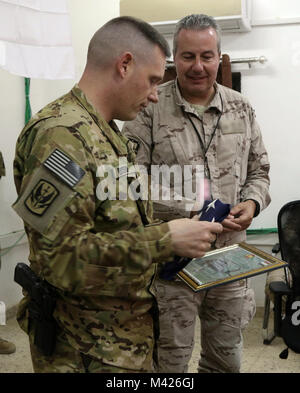 TAJI militärische Komplex, Irak: US-Army 449th Combat Aviation Brigade Commander lt Col Joseph Bischof (links), präsentiert die Soldaten der spanischen Armee mit der Fahne, die auf ihre Flugzeuge in den Irak während der Eröffnungs-Aufklärung Besuch im Camp Taji, Irak, Feb 1, 2018 geflogen wurde zugewiesen. Die spanische Armee wird mit der 449Th CAB integrieren Luftverkehr als Teil der gesamten Combined Joint Task Force-Operation inhärenten Building Partner Kapazität mission lösen, die über die Ausbildung und die Verbesserung der Fähigkeit der zusammengeschlossen, um Kräfte, die ISIS konzentriert sich zu erweitern. CJTF-OIR ist der globale Coa Stockfoto