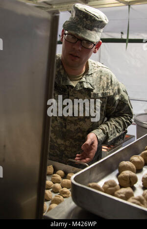 Sgt. Eric Burmeister, einem US-amerikanischen Armee-reservesoldat aus seiner 530 Militärpolizei Bataillon, unter der 200 MP Befehl, Orte Brötchen in einem Feld Backofen in einer mobilen Küche zelt Feb 3, 2018, in Lager Ashland, Nebraska. Die seiner 530 MP Mrd.. sind eine der vier Finalisten, die die US-Armee Finden konkurrieren in der Abteilung der Armee Philip A. Connelly Auszeichnungen für Exzellenz in der Armee Food Service Wettbewerb in diesem Jahr. (U.S. Armee Fotos von Sgt. 1. Klasse Carlos J. Lazo) Stockfoto