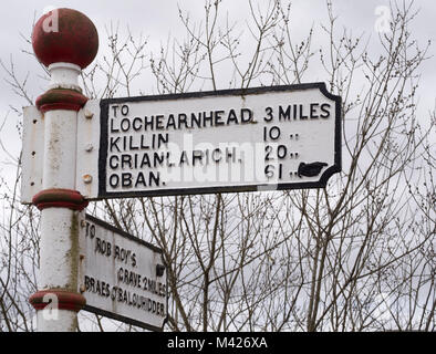 Reisende in Richtung fingerpost Zeichen Regie Rob Roy's Grab oder in Richtung Lochearnhead, Balquhidder, Perthshire, Schottland, Großbritannien. Stockfoto