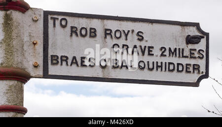 Reisende in Richtung fingerpost Zeichen Regie Rob Roy's Grab, Balquhidder, Perthshire, Schottland, Großbritannien. Stockfoto
