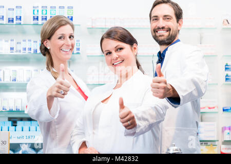 Apotheker in der Apotheke zeigen Daumen hoch Stockfoto