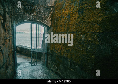 Tür mit berjas und Wand mit alten Moos an der Wand des Schlosses von Baiona Stockfoto