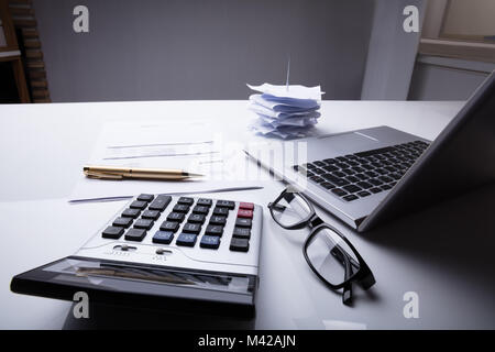 Close-up von Dokumenten mit Rechner und Laptop auf dem Schreibtisch Stockfoto