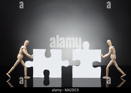 Zwei Mannequins Lösung weiß Puzzle auf grauem Hintergrund Stockfoto