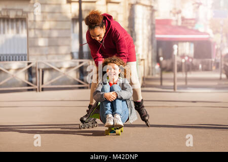 Portrait von Multiethnischen Jugendliche, gerne Freunde mit Skateboard und Inline Skates, Spaß haben, gemeinsam in der Stadt Stockfoto