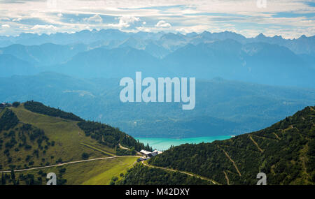 Fernsicht auf Gästehaus auf Wanderweg in den Alpen gegen turqiose See und Bergrücken Stockfoto