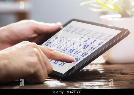 Nahaufnahme der Kaufmann Hand mit Kalender auf Digital Tablet Stockfoto