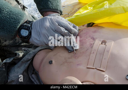 FORT MCCOY, Wis-US Army Reserve SPC. Jonathan Hessel, Sanitäter, Task Force Triade, Betrieb Cold Steel II, führt eine Brust Dekomprimierung auf notfallpatient Simulator während einer medizinischen Evakuierung Probe am Fort McCoy, Wis., Feb 8, 2018. Betrieb Cold Steel ist der US-Armee finden Crew - Serviert Waffen Qualifizierung und Validierung ausüben, um sicherzustellen, dass America's Army Reserve Einheiten und Soldaten ausgebildet sind und bereit, auf kurze bereitstellen - Bekanntmachung als Teil bereit, Kraft X und überall in der Welt bekämpfen - bereit und tödlichen Feuerkraft zur Unterstützung der Armee und unsere gemeinsamen Partner bringen. (U.S. Arm Stockfoto