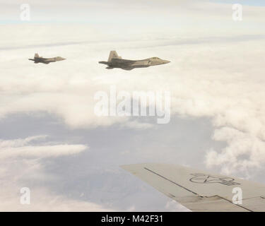 F-22 Raptors aus der Texas Air National Guard fliegen entlang einer KC-135 R vor dem Erwerb durch die 117 Luftbetankung Flügel, Sumpter Smith Air National Guard Base, Birmingham, Ala., 24. Januar 2018 betankt. (U.S. Air National Guard Stockfoto