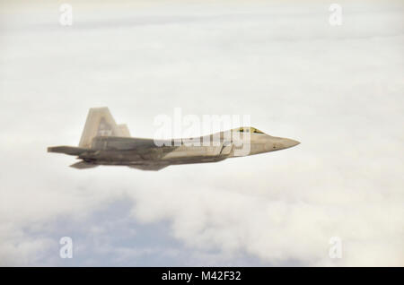 Eine F-22 Raptor von der Texas Air National Guard fliegt entlang einer KC-135 R, nachdem durch die 117 Luftbetankung Flügel von sumpter Smith Air National Guard Base, Birmingham, Ala., 24. Januar 2018 betankt wird. (U.S. Air National Guard Stockfoto