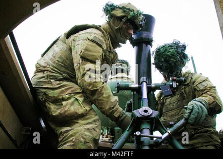 Us-Armee SPC. Rickey Wendorf, Links, und Pfc. Riley Clare, sowohl indirekte Feuer Infanteristen an 2nd Battalion, 70th Panzer Regiment, 2. gepanzerte Brigade Combat Team, 1.Infanterie Division, Ziel einer 120 mm M 121 Carrier-Waffe System während einer Live-fire Übung in Grafenwöhr Training Area, Deutschland, Feb 8, 2018 montiert. Die übung war die Geschwindigkeit des Geräts, die Genauigkeit und die Bereitschaft zu testen. (U.S. Armee Stockfoto