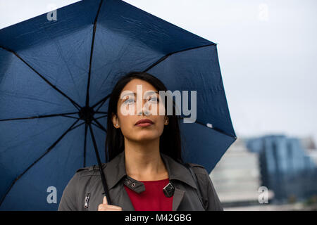 In der Stadt halten Regenschirm in schlechtem Wetter Geschäftsfrau Stockfoto