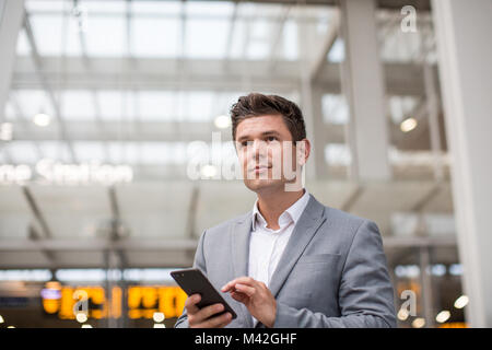 Pendler im Zug mal am Bahnhof holding Smartphone Stockfoto