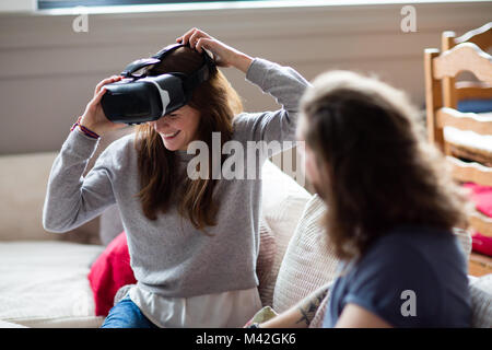 Junge erwachsene Frauen setzen auf VR-Headset Stockfoto