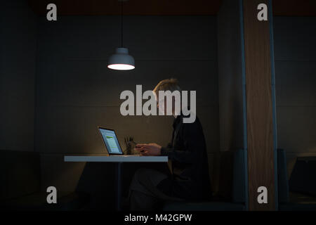 Geschäftsfrau, die spät in der Nacht im Büro allein Stockfoto