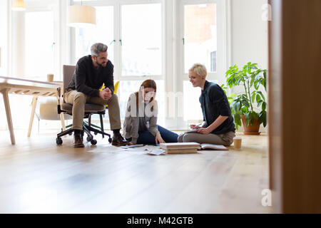 Gruppe von Designern Ideen diskutieren mit Papierkram auf Büro Etage Stockfoto
