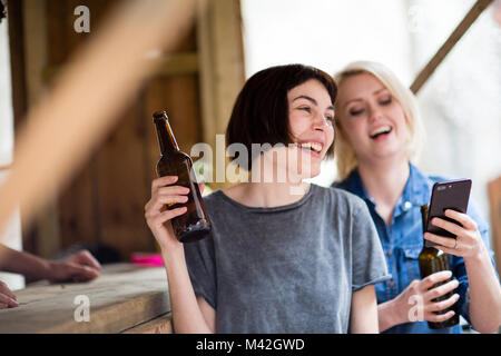 Zwei Freunde, die an einem Street Food Bar Bier trinken. Stockfoto