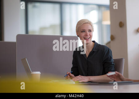 Geschäftsfrau im Gespräch mit Kollegen bei der Arbeit Stockfoto