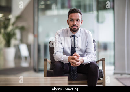 Unternehmer selbstbewusst in die Kamera schauen Stockfoto