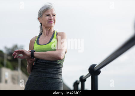 Ältere Frau Aufwärmen vor einem Lauf Stockfoto