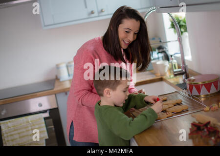 Mutter und Sohn Lebkuchen verzieren Männer Stockfoto