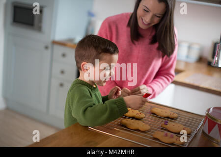 Mutter und Sohn Lebkuchen verzieren Männer Stockfoto