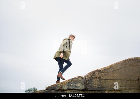 Junge männliche Wandern auf einem steilen Hügel Stockfoto