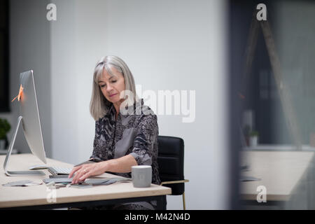 Senior Geschäftsfrau arbeiten im Büro Stockfoto