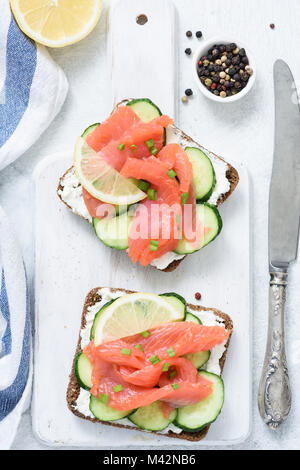 Geräucherter Lachs, Quark und Gurken toast Sandwiches auf Weiß. Ansicht von oben Stockfoto