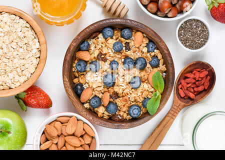 Hausgemachtes Müsli mit Nüssen und Rosinen, Blaubeeren, Getrocknete Goji Beeren, Chia Samen und Joghurt. Ansicht von oben. Konzept der gesunden Lebensstil, Diät, Gesundheit Stockfoto