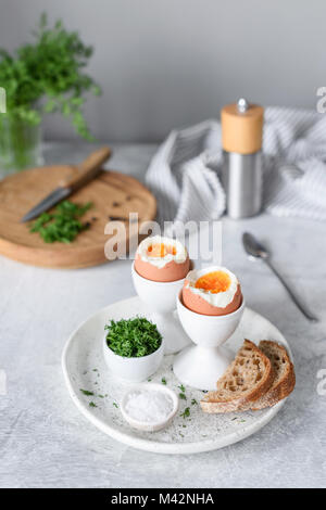 Weich gekochte Eier und Toast zum Frühstück auf cocnrete Hintergrund. Selektive konzentrieren. Gesunde Ernährung, gesunde Lebensweise Konzept Stockfoto