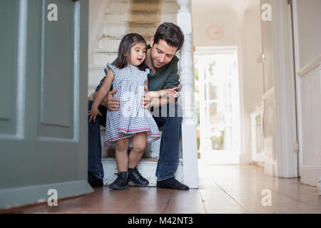 Vati hilft Tochter zu Fuß Stockfoto