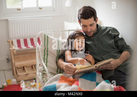 Vater lesen Tochter eine Gutenachtgeschichte Stockfoto