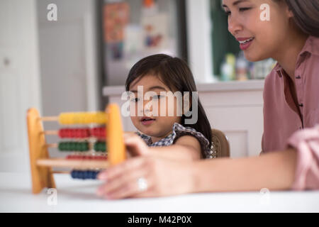 Mädchen mit Abacus mit der Mutter zu zählen Stockfoto