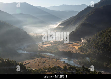 Punakha, Bhutan. Am frühen Morgen Sonne beleuchtet Morgennebel in der Mo River Valley. Stockfoto