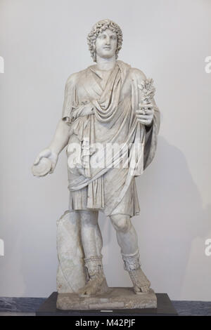 Farnese Lar. Römische Statue aus Marmor aus dem 2. Jahrhundert N.CHR. aus der Sammlung Farnese auf Anzeige im Nationalen Archäologischen Museum in Neapel, Kampanien, Italien. Jugend in einer kurzen Tunika mit einem Umhang gerichtet Idealisierte und Halten einer Patera in der rechten Hand. Die Statue wurde durch den italienischen Bildhauer Carlo Albacini wiederhergestellt. Stockfoto