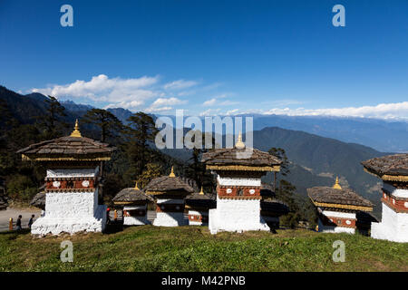 Punakha, Bhutan. Chörten (Schreine) bei einem Pass in den Ausläufern des Himalaja, Himalaya Berge in der Ferne. Stockfoto