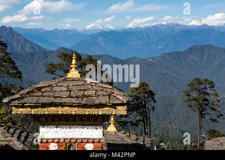 Punakha, Bhutan. Chörten (Schreine) bei einem Pass in den Ausläufern des Himalaja, Himalaya Berge in der Ferne. Stockfoto