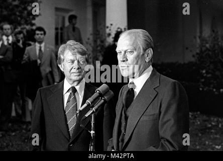 Präsidenten der Vereinigten Staaten Gerald R. Ford, rechts, und der designierte US-Präsident Jimmy Carter, Links, Reporter außerhalb des Oval Office des Weißen Hauses in Washington, D.C. nach ihrer Diskussionen über den Übergang am 22. November 1976. Dies ist das erste Treffen zwischen den beiden Männern seit den Präsidentschaftswahlen Debatten während der Kampagne. Credit: Benjamin E. 'Gene' Forte/CNP/MediaPunch Stockfoto