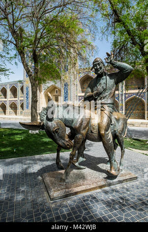 Buchara, Usbekistan, in Zentralasien. Das Denkmal zu Nasreddin Hodscha und der Nadir Divan-Beghi madrasah im Hintergrund. Stockfoto