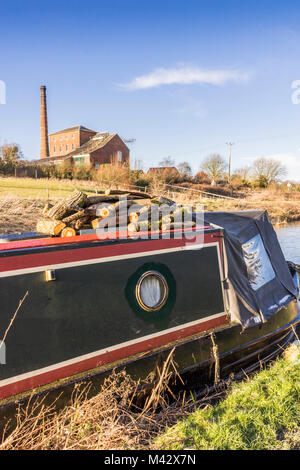 Narrowboat auf dem Kennet- und Avon-Kanal im Winter und die Crofton Pumpstation (Crofton Beam Engines) im Hintergrund, Wiltshire, England, Großbritannien Stockfoto