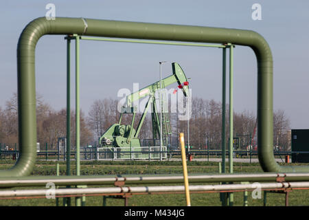 Emlichheim, Deutschland. 8 Feb, 2018. Ein Blick auf ein Pferd Kopf Pumpe unter einer Pipeline in Emlichheim, Deutschland, 8. Februar 2018. Erdöl ist seit mehr als 70 Jahren in der Grafschaft extrahiert. Öl Produzent Wintershall zielt darauf ab, neue Ölfelder mit seismischen Messungen zu entdecken. Credit: Friso Gentsch/dpa/Alamy leben Nachrichten Stockfoto